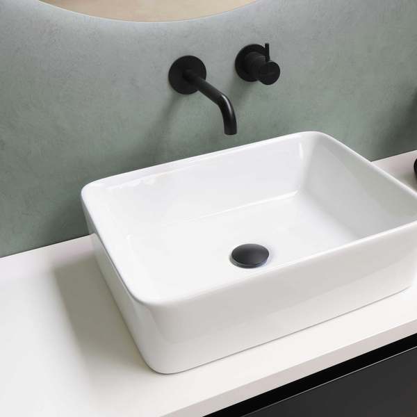 White rectangular basin on a white worktop with a matt black wall-mounted tap against a sage green wall
